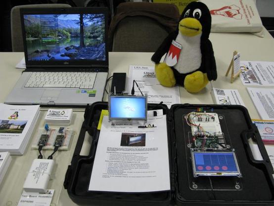 Foto: Ein Ausschnitt von unserem Tisch. Ein Linux Notebook, unser FrankenTux, unsere RasPI Projekte. Im Hintergrund rechts oben unsere Tux-Taschen.