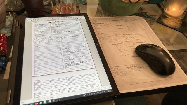 Ein Charakterdokument in digitaler Form neben dem gleichen in Papierform.