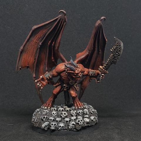 Big red winged demon with a sword on a pile of skulls
