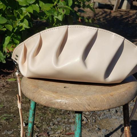 a shoulder bag that resembles a mandu (Korean for dumpling) on a stool