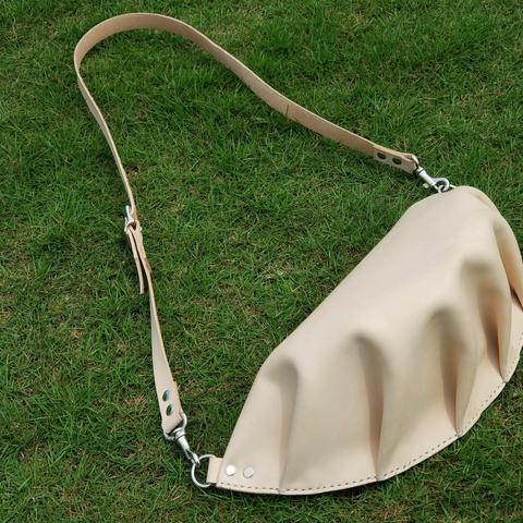 a shoulder bag that resembles a mandu (Korean for dumpling) on the grass