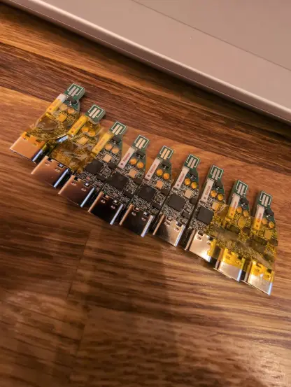 10 rudelblinken PCBs on my table. They are around 30x10mm each, have a USB C port, an ESP32, and pads where an LED strip can be soldered on