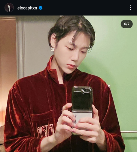 screenshot from ElCapitxn's IG 
taking a mirror selfie 
visage, coif, and hands 
in a crimson velvet robe 
LV earrings 
this man is so beautiful