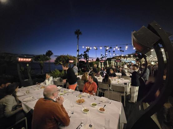 Dinner with team on an outdoor patio overlooking the ocean and sunset.