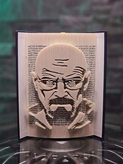 A photo showing a book sculpture featuring a three-dimensional portrait of Walter White from Breaking Bad along the edges of its pages.