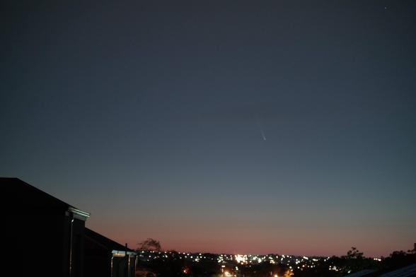 Looking to the Eastern horizon over Perth suburbs, a two story house to the left, silhouetted against the gradually reddening sky.
Comet Tsuchinshan-ATLAS is rising above the lights of the suburbs.