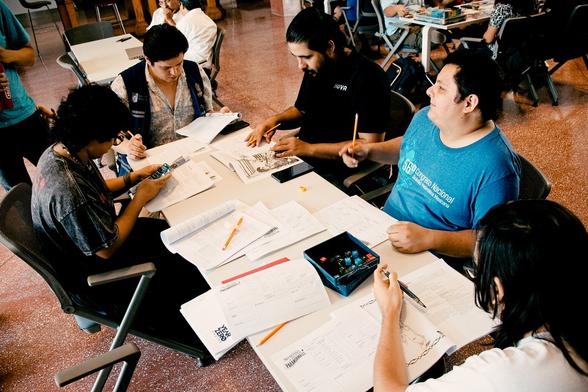 Jugadores alrededor de una mesa preparando fichas de personajes del juego de rol "Secretaría de Asuntos Paranormales". LudoReunión del mes de agosto organizada por LudoWars con sede en el LabNL de la ciudad de Monterrey.