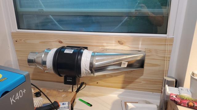 Window exhaust board, in a window next to a K40+. The board has an xTool 6in blower connected to a 4x10in exhaust vent. A 4in reducer is in place, waiting for the hose from the laser.