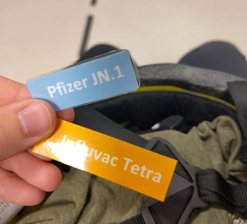 Two 'tokens' with "Pfizer JN.1" and "Influvac Tetra" written on it.