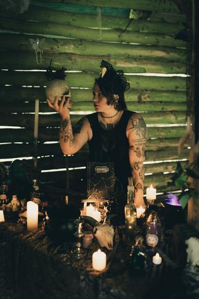 Witch in a dark hut holding a skull