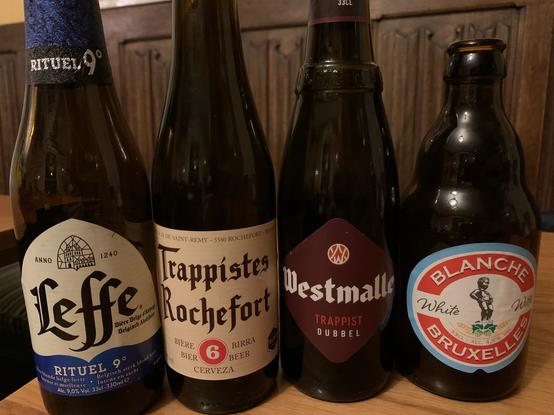 Four bottles of Belgian beer on the table in a bar.