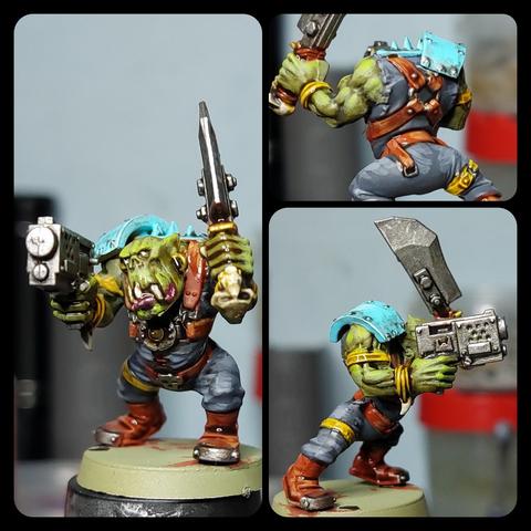 Collage of an orc boy from three angles. He's positively covered in straps because the sculptors back in the day loved leather and ugly faces I guess. His face is particularly ugly because he's got one tooth sticking over his lower lip and I painted his eyeballs white but did not add a pupil. Like way too many of these orcvoys his wielding a cleaver type sword with little skull at the pommel and a simple handgun.
