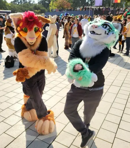 Two Partial feline fursuiters crossing their arms and legs, trying to make a torture dance pose from Jojos Bizarre Adventure: Golden Wind