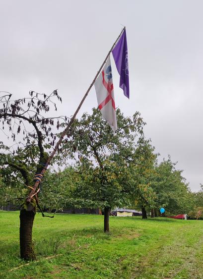 Die DPSG und die WOSM Fahne an einem schrägen Mast.