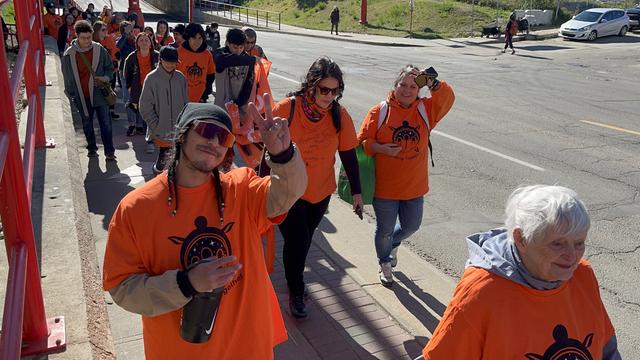 People marching wearing orange shirts.