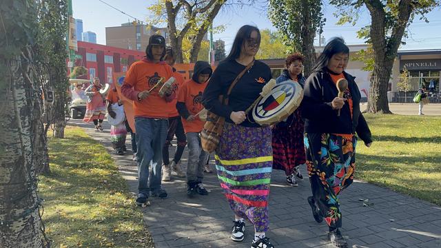 Indigenous Elder and drummers marching in a mark.