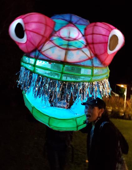 My head being chomped by giant glow fish. Large walking puppet at the festival.