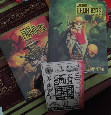 Trois livres de JDR : les deux ouvrages de Weird Frontier (DCC) et Frontier Scum