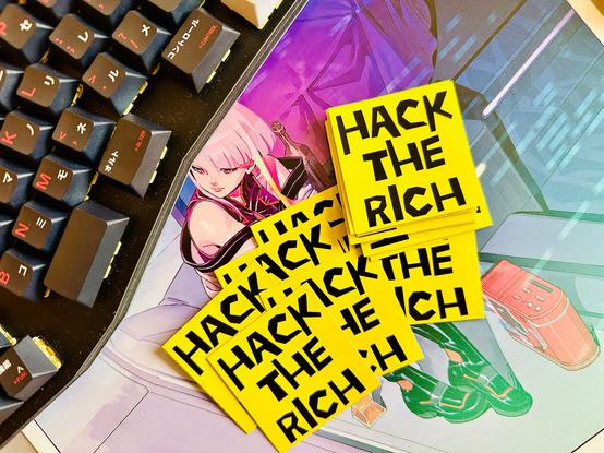 Several yellow stickers with the words "Hack The Rich" in bold black letters.