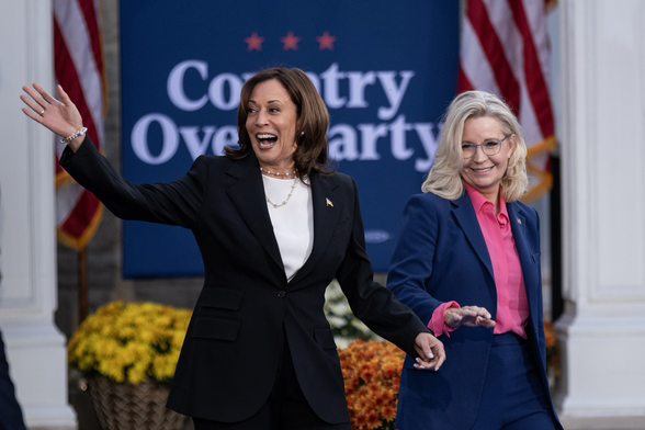 Harris e Cheney salutano i partecipanti al comizio di Ripon. Dietro di loro un manifesto proclama “Country over Party”, il Paese prima del Partito.