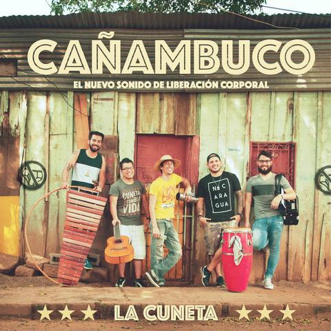 Image of the album cover for La Cuneta - Ca​ñ​ambuco. Shows the five members of the band with instruments standing in front of a run down small building.