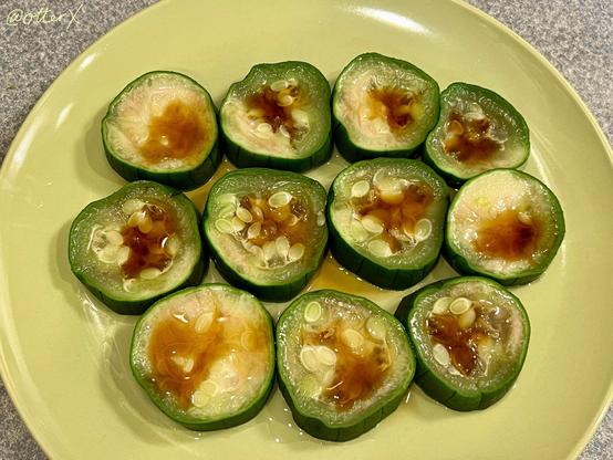 The same cooked luffa gourd seasoned with lemon ponzu on the same plate on the kitchen counter.