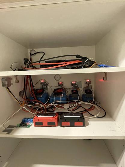 Die ersten beiden Fächer vom Solarschrank 2. Oh, da ist meine Brille :-)
Im ersten Fach ist der Hoymiles Wechselrichter.
Im zweiten Fach sind die Orions und die Verteilung und die Temperatursteuerung der Lüfter.
Sehr dominant im Vodergrund der Vereteiler. Links daneben die ZigBee-Platine, die über FHEM die Orions ein- oder ausschaltet.
Das unscheinbare kleine weisse Kästchen ist ein Zigbee-Temperatur-Sensor. Er meldet über das Alexa-System, wenn die Temperatur bestimmte Werte erreicht.
Es fehlt noch der Lüfter, der die warme Luft nach draussen pustet.