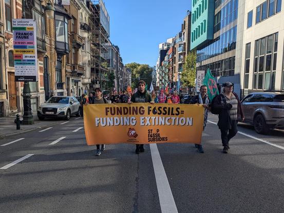 Das Menschen mit einem Banner "Funding Fossil = Funding Extionction"