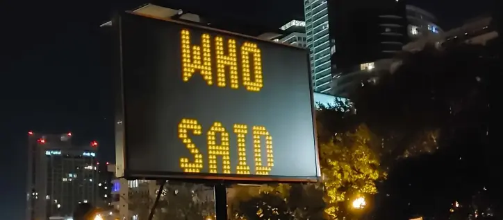 A picture of a digital traffic sign saying, "WHO SAID".