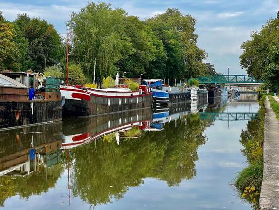 Hausboote spiegeln sich im Wasser des Kanals in Nancy.