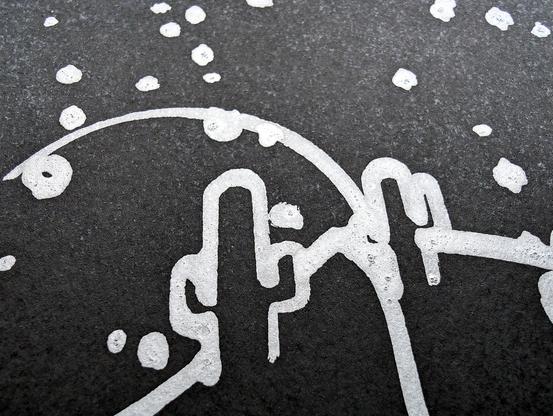 A minimalist desert scene under a moonlit sky, created using a pen plotter programmed to dip a paintbrush into silver metallic ink. The crescent moon floats above abstracted desert dunes and cacti, outlined in smooth lines. Scattered stars are represented with silver ink dabs, creating a serene, expansive night sky. The reflective quality of the silver ink against the black background evokes the calm and solitude of a desert night. In close-up, the textured silver ink stars have a cratered, hand-painted appearance, adding dimension. The crescent moon is detailed with metallic strokes, enhancing the organic feel of the scene. This piece meditates on the quiet of a desert night, its calm reinforced by each star and line being hand-programmed—each element unique, like every night spent under the sky.