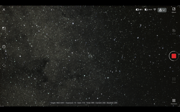 A screenshot of a smart telescope display, with controls around the edge, and a legend showing the target and exposure settings at the bottom. In the middle there is a small cluster of stars, and to the left a broad nebula, with a single dark dust lane.