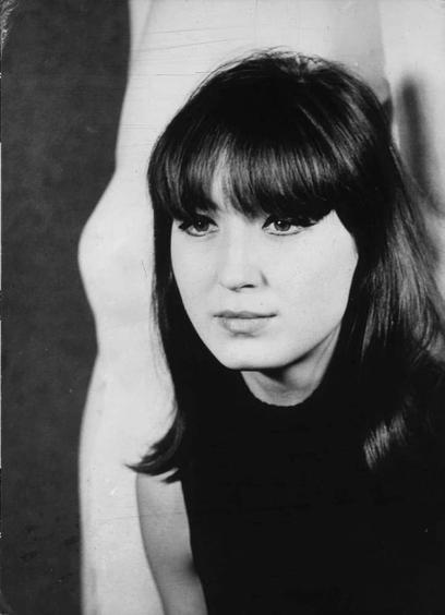 The image is a black and white portrait of an individual. The person appears to be wearing bangs that fall across their forehead, framing the eyes which have dark eyeliner. Their gaze is directed towards something out-of-frame with a neutral expression on their face. They are dressed in what seems like a simple, possibly sleeveless top or dress as suggested by the visible lines of clothing at shoulder level and below.

The background is nondescript and does not provide any additional context; it's primarily dark which contrasts sharply against the lighter tones around where the individual’s head and shoulders fall. The overall composition focuses on capturing an intimate yet enigmatic mood, emphasized through monochrome photography that lacks color cues but relies heavily on contrast to create depth.

The image is labeled as "Agi, Antonio - Milena," suggesting it might be a photograph of or associated with someone named Milena captured by Agi Antonic. Additional information about this specific photograph can likely be found in the referenced web page mentioned in your query.