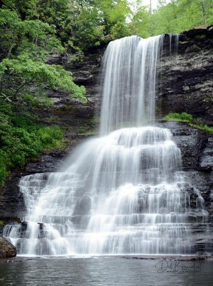 A beautiful waterfall at The Cascades in Pembroke, Virginia, gracefully descending over layered rock formations into a peaceful pool below. Surrounded by lush green foliage.  Image at:  https://beautifulsunphotography.com/featured/cascading-beauty-in-virginia-deb-beausoleil.html  See more art & blog at: https://beautifulsunphotography.com/ https://debbeautifulsunphotography.com/ https://www.zazzle.com/store/beautifulsun_designs https://debbeausoleil.com https://www.artpal.com/BeautifulSun/