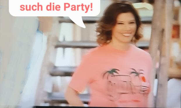 Fernsehansagerin in rosa mit Spruch: such die Party.