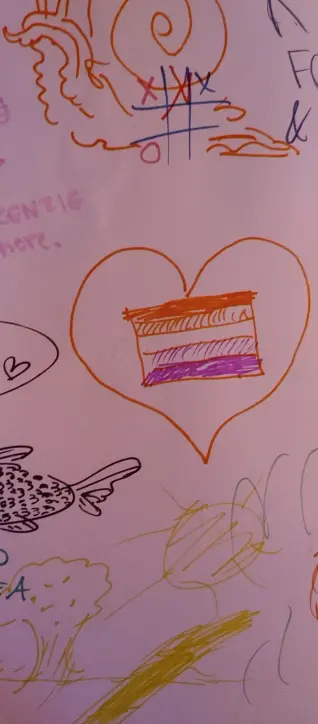 Many different stuff on the wall. The main drawing is an LGBT flag inside of a heart.