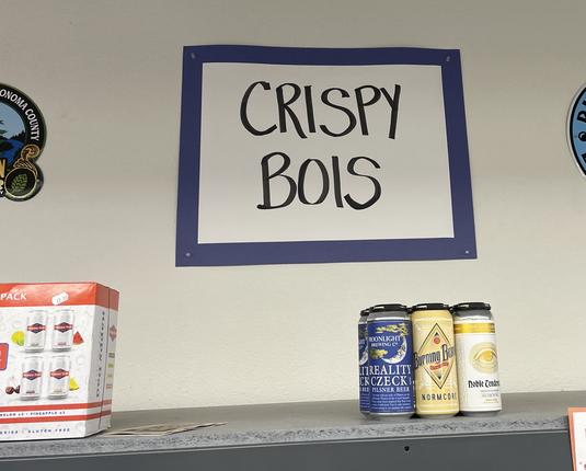 A beer store display sign reading “CRISPY BOIS”