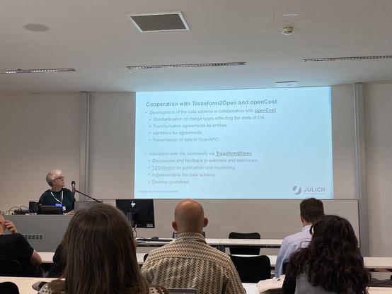 Ds Bild zeigt Irene Barbers bei ihrem Vortrag bei der openCost-Konferenz