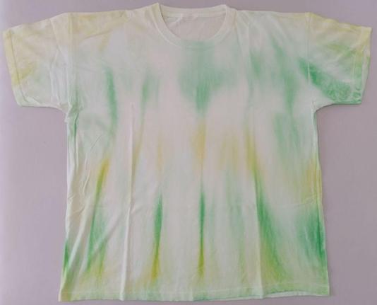Weißes T-Shirt mit gelben und grünen Batik Mustern.