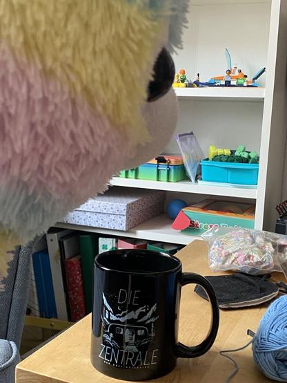 Der kopf eines Regenbogen Alpakas welches Tee aus einer Tasse mit Der Zentrale der Drei ??? Darauf.
