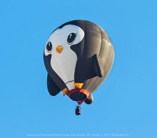 Hot air ballon shaped like a penguin against a clear blue sky.
©BosqueBill.com