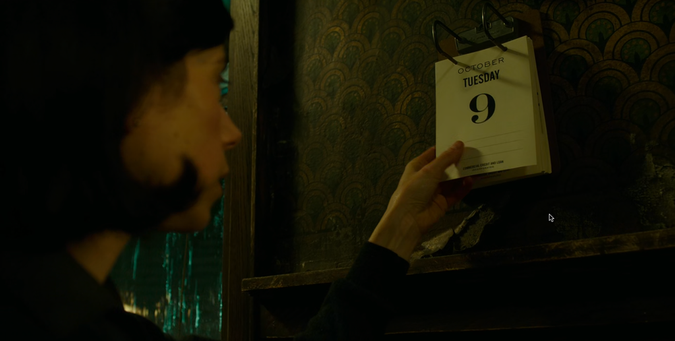 A woman holds a calendar page dated October 9, Tuesday