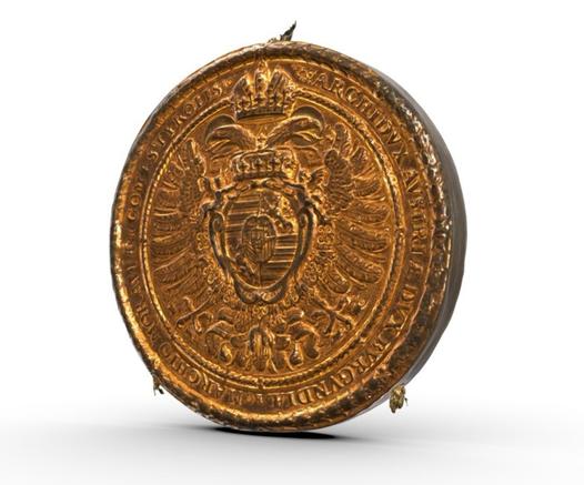 Goldbulle an der Urkunde zur Erhebung des Grafen Johann von Hohenzollern in den Reichsfürstenstand durch Kaiser Ferdinand II. Das Siegel besteht aus zwei dünnen Goldblechen, in die die Motivstempel hineingetrieben und die danach miteinander verbunden wurden. Der Hohlraum der Siegel wurde in der Regel mit Wachs aufgefüllt. Signatur: Landesarchiv Baden-Württemberg, Staatsarchiv Sigmaringen FAS HS 1-80 T 1-6 U 209.