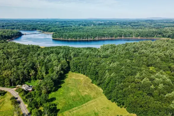 aerial photo of a flat landscape with a large river, forests, and meadows
