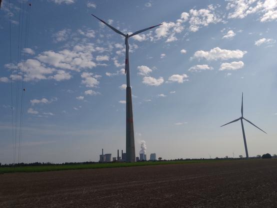 (Herkömmliches) Windrad vor Kohlekraftwerk.