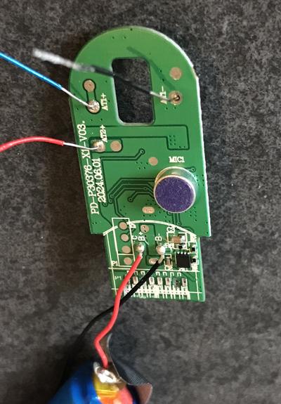 The PCB of an electronic cigarette. Apart from a few wires that lead to the battery and the heater there’s a round component with a fabric like top that’s labelled “MIC1”.