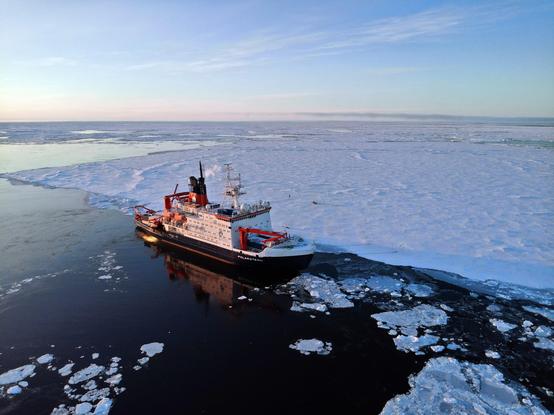 aerial photo of a large icebreaker in the arctic ocean
