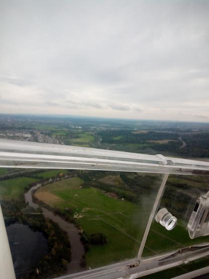 Blick aus dem Cockpit eines Segelflugzeuges während des Fluges. ZU sehen ist eine Naturlandschaft mit Lahn und Dörfern.