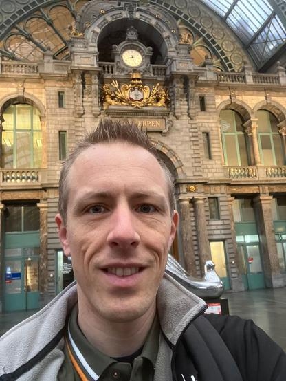 Hanno in front of the historic clock of Antwerpen Central Station