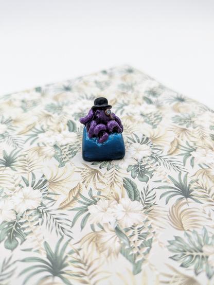 Une touche de clavier mécanique avec un poulpe portant un chapeau et un monocle dessus